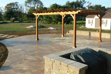 Diseño de patio exótico de tamaño medio en patio trasero con adoquines de piedra natural y pérgola