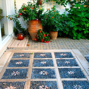 Idee per un piccolo patio o portico boho chic in cortile con pavimentazioni in pietra naturale
