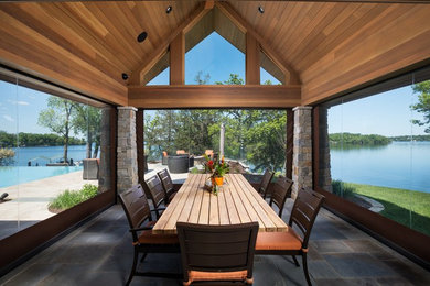 Inspiration pour une grande terrasse arrière craftsman avec un foyer extérieur, des pavés en pierre naturelle et une pergola.
