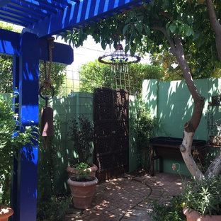 Foto di un piccolo patio o portico bohémian dietro casa con pavimentazioni in mattoni e una pergola