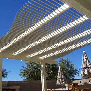 Idee per un piccolo patio o portico stile americano dietro casa con pavimentazioni in pietra naturale e una pergola