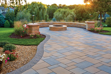 Example of a mid-sized transitional backyard concrete paver patio design in Minneapolis with a fire pit and no cover
