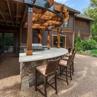 Idee per un grande patio o portico stile americano dietro casa con lastre di cemento e una pergola