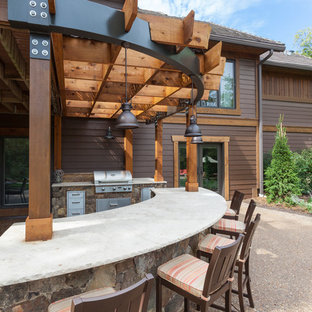 Ispirazione per un grande patio o portico american style dietro casa con lastre di cemento e una pergola