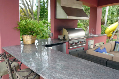 マイアミにある広いコンテンポラリースタイルのおしゃれな裏庭のテラス (アウトドアキッチン、タイル敷き、パーゴラ) の写真