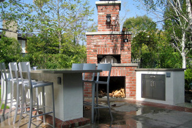 Foto de patio clásico de tamaño medio sin cubierta en patio trasero con cocina exterior y losas de hormigón