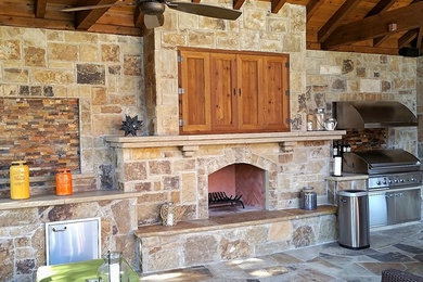 Example of a mid-sized mountain style backyard stone patio kitchen design in Dallas with a gazebo