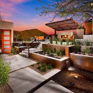 Foto di un ampio patio o portico stile americano dietro casa con un focolare, pavimentazioni in pietra naturale e nessuna copertura