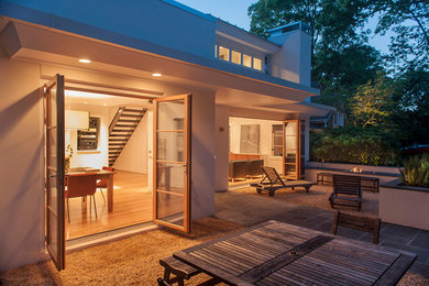 Diseño de patio actual de tamaño medio sin cubierta en patio trasero con brasero y gravilla