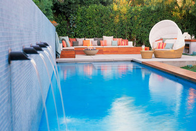 This is an example of a large contemporary back swimming pool in Los Angeles with concrete slabs.