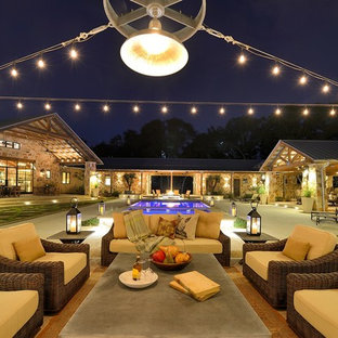 Immagine di un grande patio o portico american style dietro casa con lastre di cemento