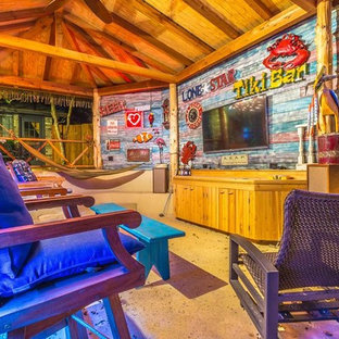 Immagine di un patio o portico tropicale di medie dimensioni e dietro casa con un gazebo o capanno