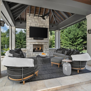 Immagine di un patio o portico chic con un caminetto e un gazebo o capanno