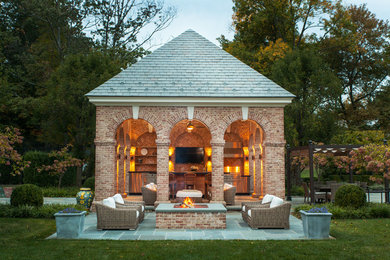 Diseño de patio tradicional grande en patio trasero con brasero, cenador y adoquines de piedra natural