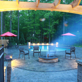 Immagine di un grande patio o portico classico dietro casa con un focolare, cemento stampato e una pergola