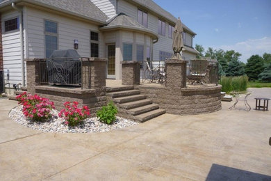 Diseño de patio clásico renovado grande sin cubierta en patio trasero con fuente y adoquines de piedra natural