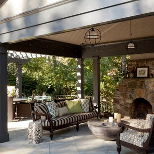 Ispirazione per un grande patio o portico american style dietro casa con un focolare, pavimentazioni in pietra naturale e un gazebo o capanno