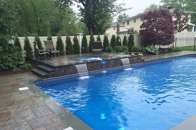 Example of a backyard stone pool design in New York