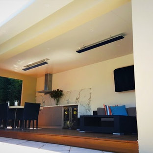 Idee per un patio o portico minimalista di medie dimensioni e nel cortile laterale con pedane e un tetto a sbalzo