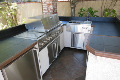 Example of a classic backyard tile patio kitchen design in Orange County