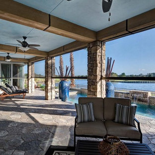 Ispirazione per un grande patio o portico mediterraneo dietro casa con un tetto a sbalzo e pavimentazioni in pietra naturale