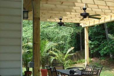 Diseño de patio de tamaño medio en patio trasero con cocina exterior, adoquines de hormigón y pérgola