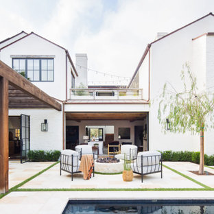 Immagine di un patio o portico tradizionale dietro casa con un focolare e nessuna copertura