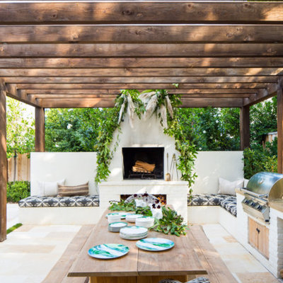 Inspiration for a transitional backyard patio remodel in Orange County with a fireplace and a pergola