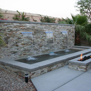 Idee per un patio o portico tropicale dietro casa e di medie dimensioni con fontane, nessuna copertura e lastre di cemento