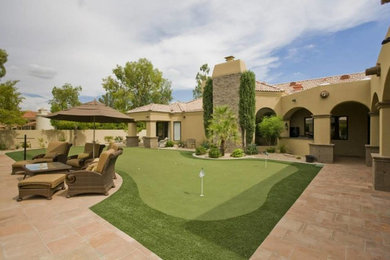 This is an example of a large mediterranean back patio in Phoenix with concrete paving and a roof extension.