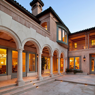 Esempio di un ampio patio o portico mediterraneo dietro casa con pavimentazioni in pietra naturale e un tetto a sbalzo