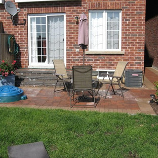 Ispirazione per un piccolo patio o portico industriale dietro casa con pavimentazioni in pietra naturale e nessuna copertura