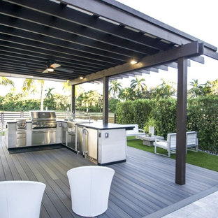 Mid-sized elegant backyard stamped concrete patio kitchen photo in Tampa with a pergola