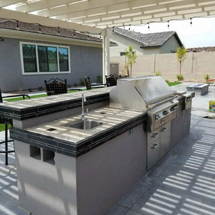 Idee per un patio o portico tradizionale di medie dimensioni e dietro casa con pavimentazioni in cemento e una pergola