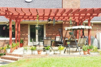 Example of a mid-sized transitional backyard concrete paver patio design in Atlanta with a pergola