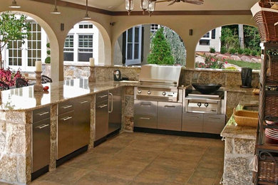 Patio kitchen - large contemporary backyard stamped concrete patio kitchen idea in Tampa with a roof extension