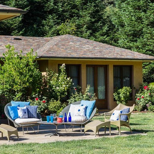 Foto di un ampio patio o portico eclettico dietro casa con pavimentazioni in pietra naturale e nessuna copertura