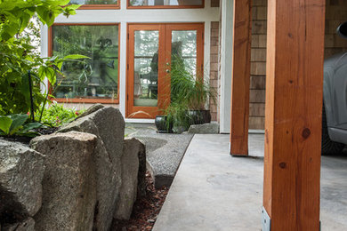 Foto di un patio o portico design in cortile con lastre di cemento e un tetto a sbalzo