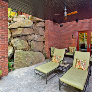 Foto di un grande patio o portico american style dietro casa con fontane, cemento stampato e un tetto a sbalzo