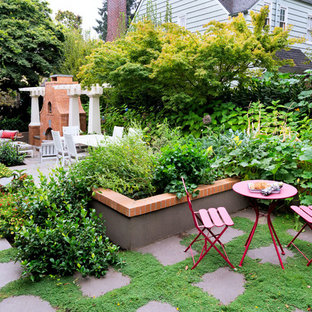 Immagine di un patio o portico boho chic di medie dimensioni e nel cortile laterale con un focolare, pavimentazioni in pietra naturale e una pergola