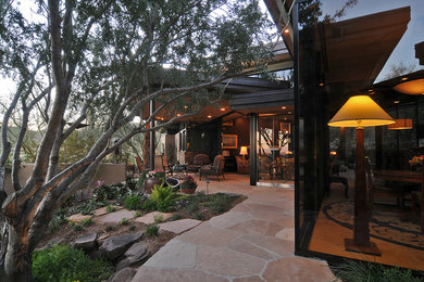 Patio - mid-sized contemporary backyard stone patio idea in Phoenix with a fire pit and a roof extension
