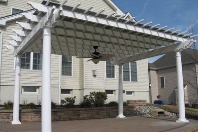 Example of a large classic backyard brick patio design in Baltimore with an awning