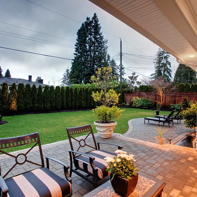 Example of a trendy concrete paver patio design in Vancouver with a roof extension