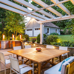 Imagen de patio tradicional, de tamaño medio, en patio trasero, con adoquines de piedra natural y pérgola
