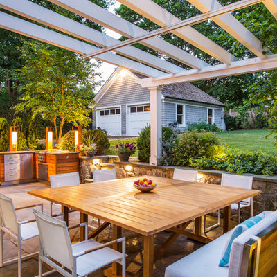 Example of a mid-sized classic backyard stone patio design in New York with a pergola
