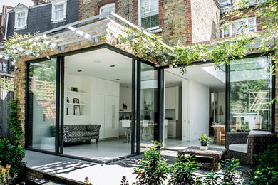 This is an example of a contemporary patio in London with a pergola.