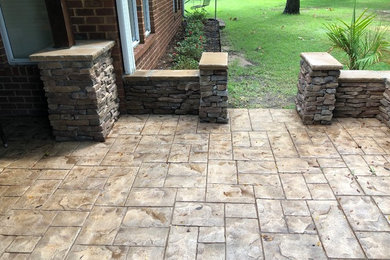 Medium sized classic back patio in Little Rock with a fire feature and stamped concrete.