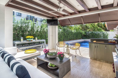Inspiration for a small mediterranean backyard tile patio kitchen remodel in Miami with a pergola