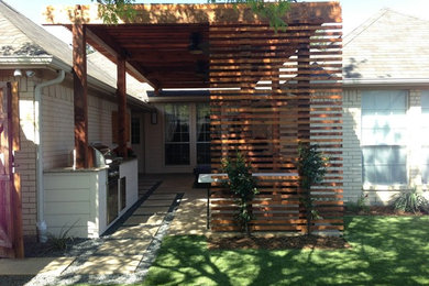 Imagen de patio moderno pequeño en patio trasero con brasero, losas de hormigón y pérgola