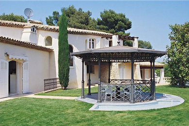 Réalisation d'une terrasse arrière méditerranéenne de taille moyenne avec un gazebo ou pavillon.